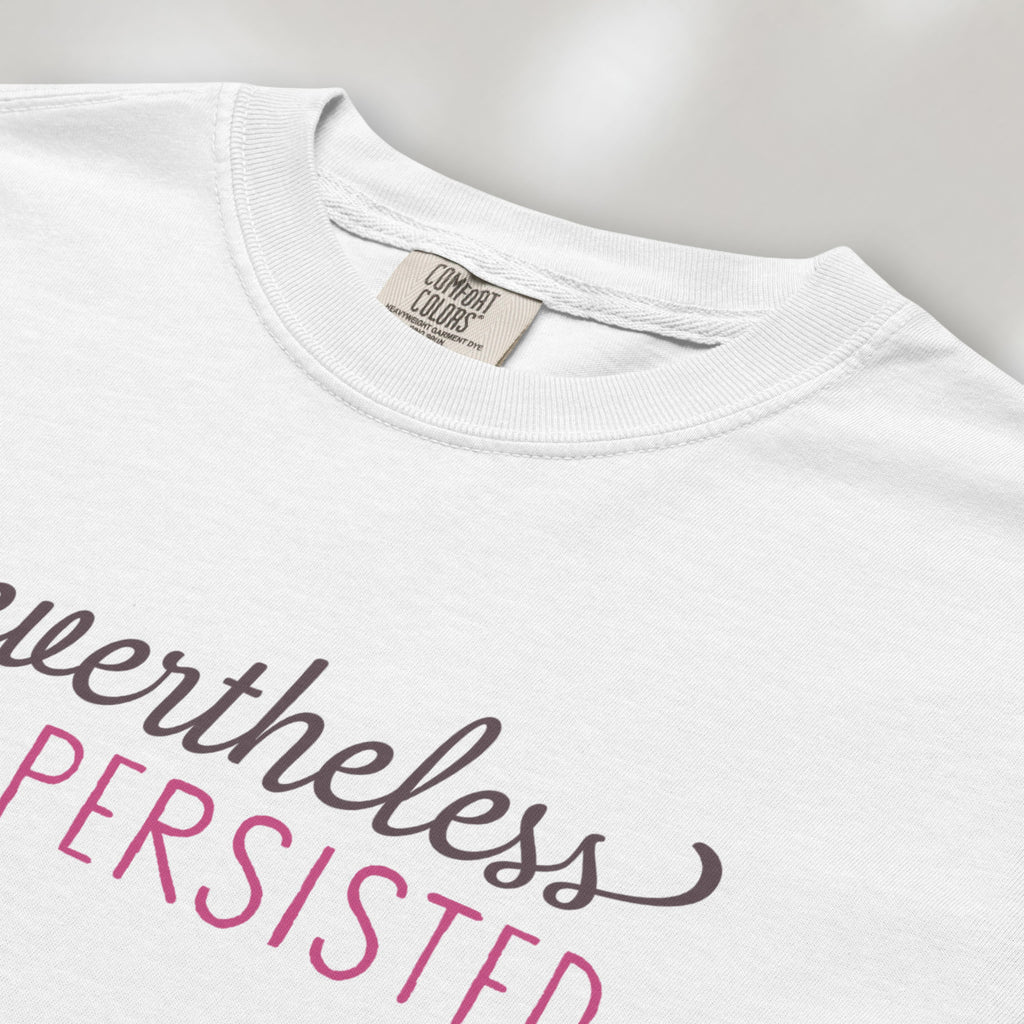Closeup detail of white t-shirt with stylized text that reads "nevertheless she persisted."