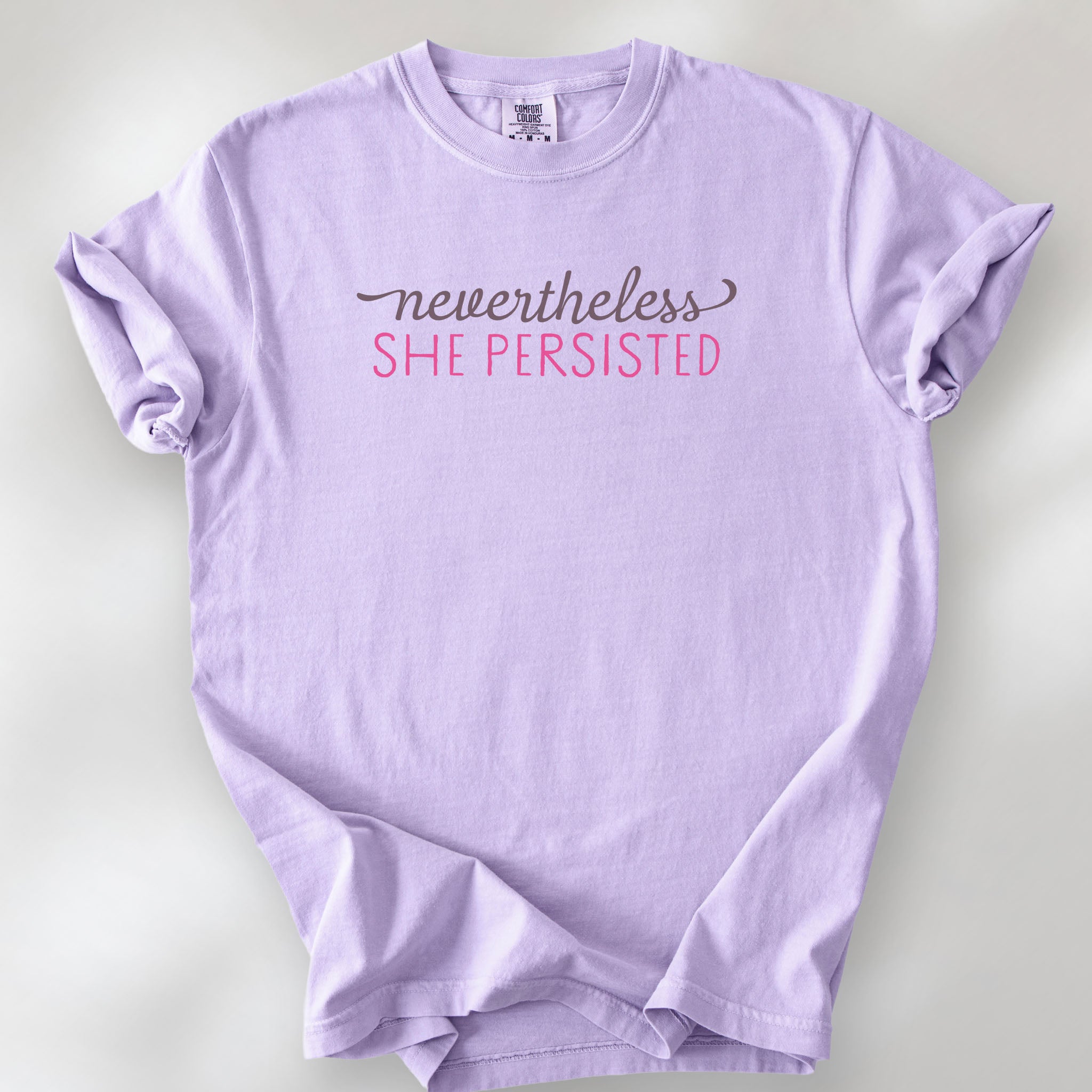 Orchid t-shirt with stylized text that reads "nevertheless she persisted."