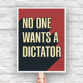 Anti-Trump protest sign with bold text reading “No One Wants a Dictator” in cream letters on red background with black shadow.