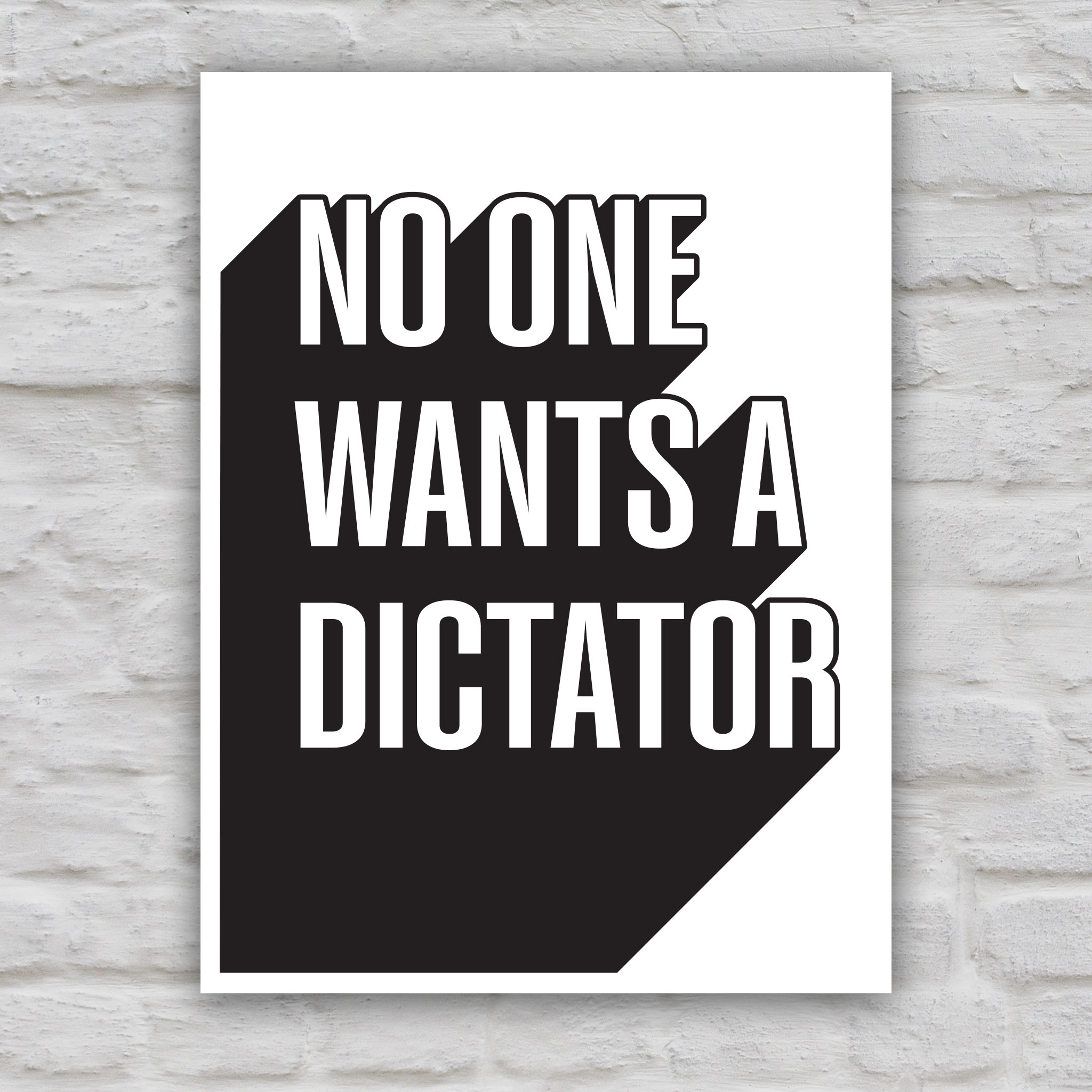 Black and white version of protest sign with bold text reading “No One Wants a Dictator” in white letters with black shadow.