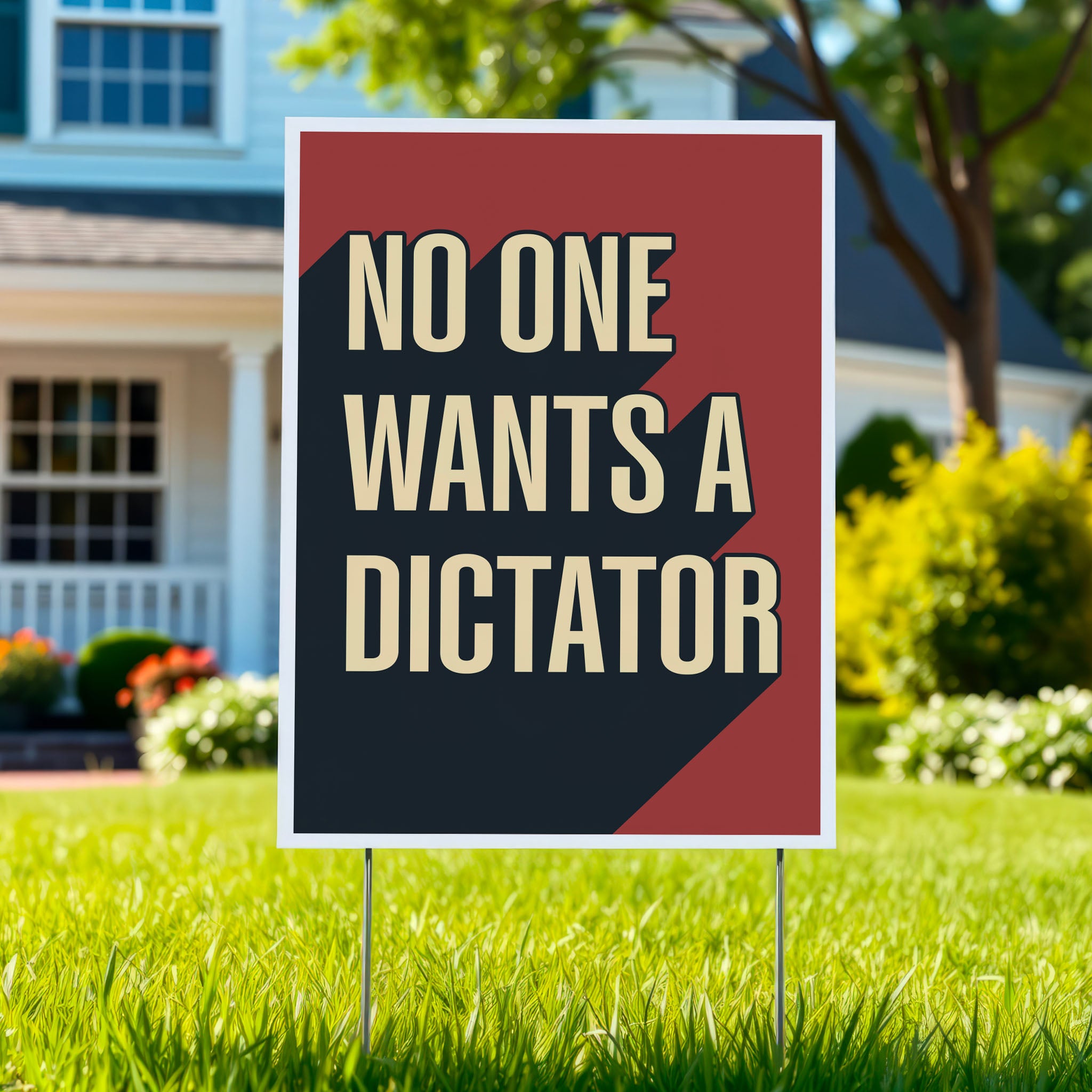 Yard sign with bold text reading “No One Wants a Dictator” in cream letters on red background with black shadow, planted in green lawn.