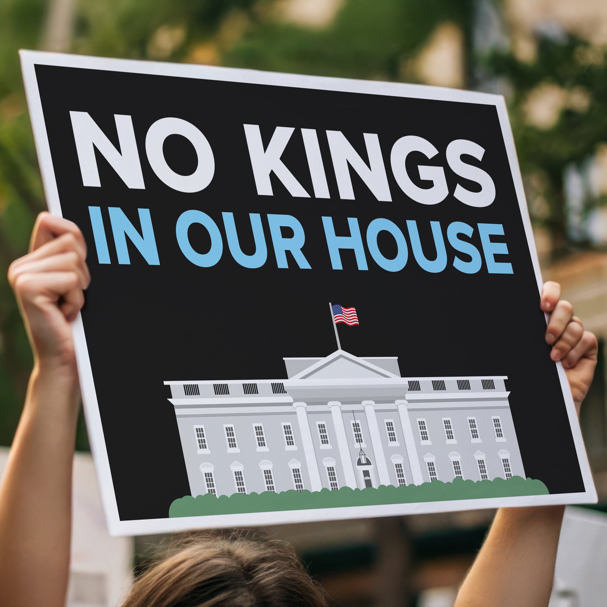 Person holding protest sign reading “No Kings in Our House” with the White House illustration, used at anti-Trump rallies and No Kings Day marches, high above a crowd.