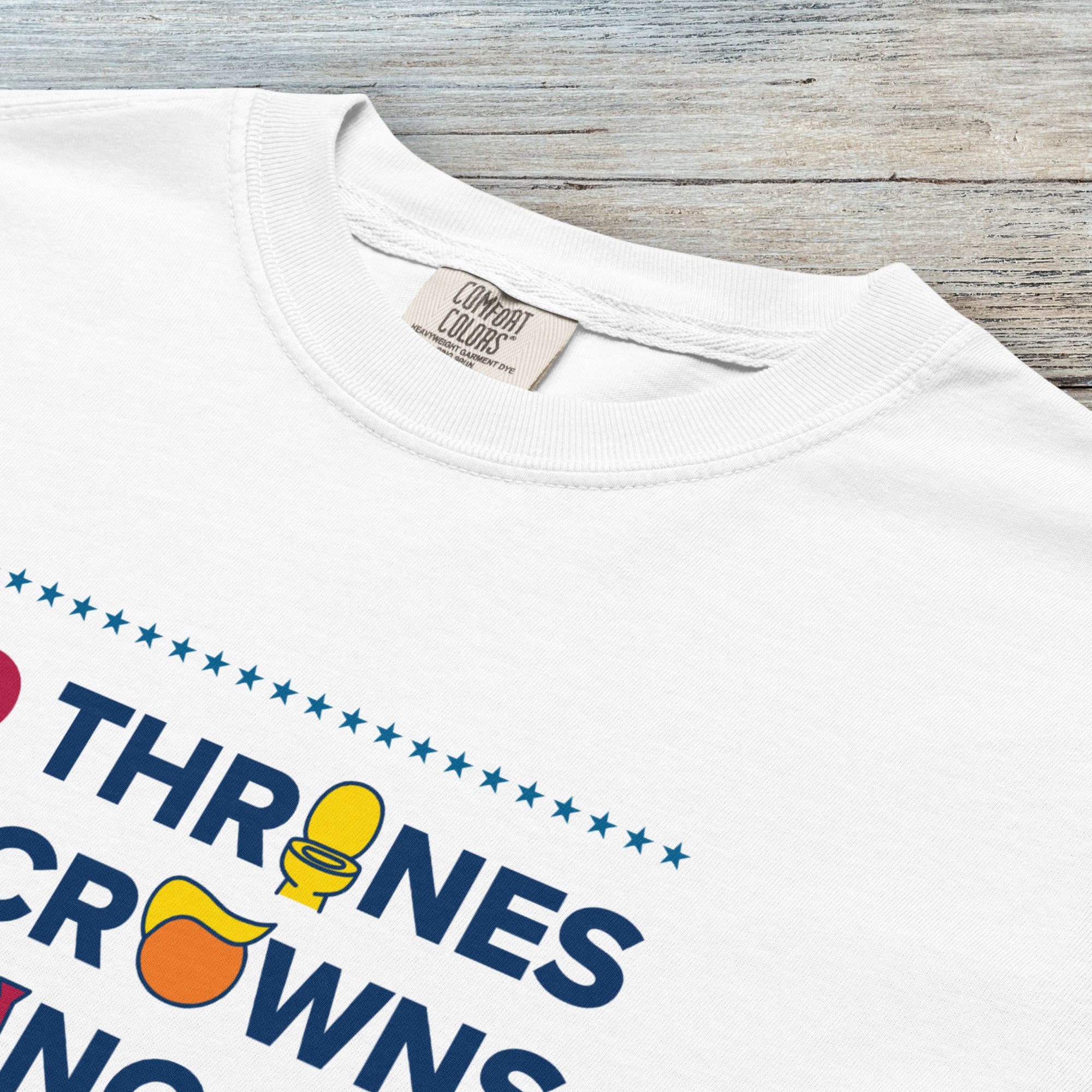 Closeup detail of white t-shirt with bold text reading “No Thrones No Crowns No Kings” featuring satirical Trump graphics: gold toilet, yellow hair, and long red tie, original anti-Trump protest shirt.