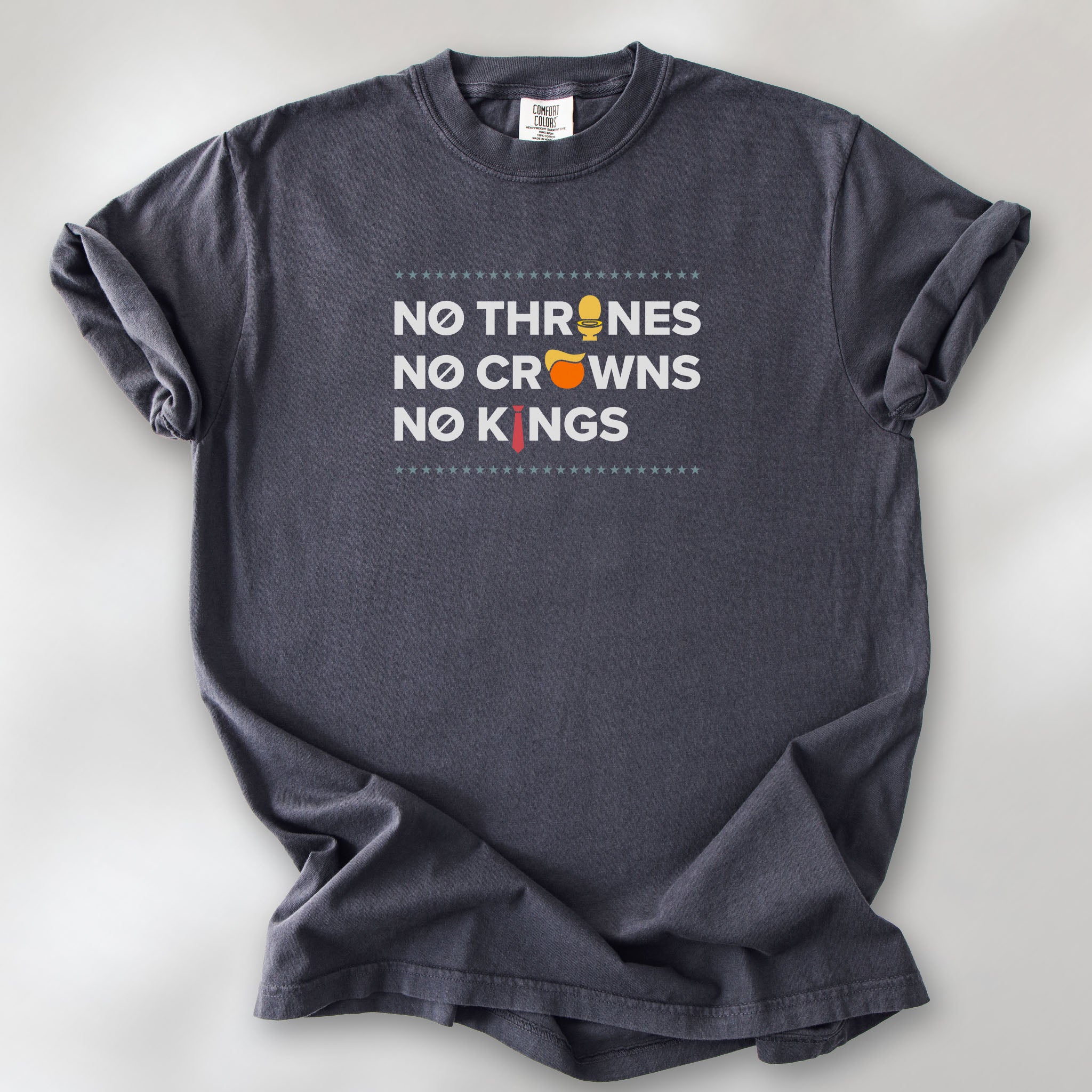 Graphite t-shirt with bold text reading “No Thrones No Crowns No Kings” featuring satirical Trump graphics: gold toilet, yellow hair, and long red tie, original anti-Trump protest shirt.