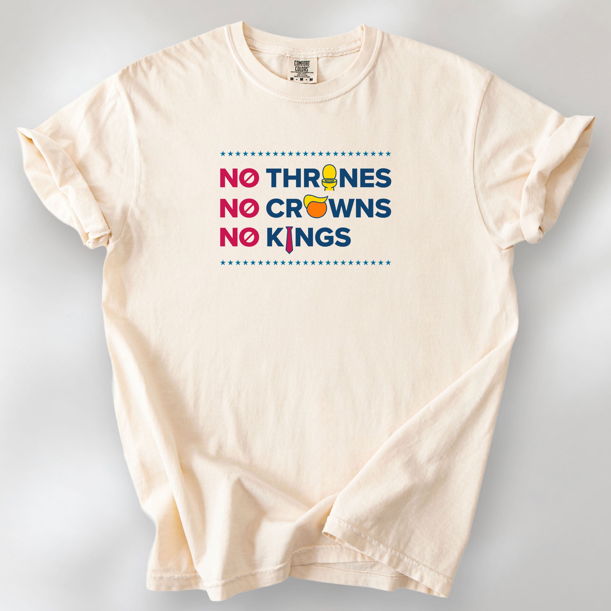 Ivory t-shirt with bold text reading “No Thrones No Crowns No Kings” featuring satirical Trump graphics: gold toilet, yellow hair, and long red tie, original anti-Trump protest shirt.