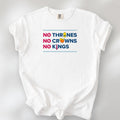 White t-shirt with bold text reading “No Thrones No Crowns No Kings” featuring satirical Trump graphics: gold toilet, yellow hair, and long red tie, original anti-Trump protest shirt.