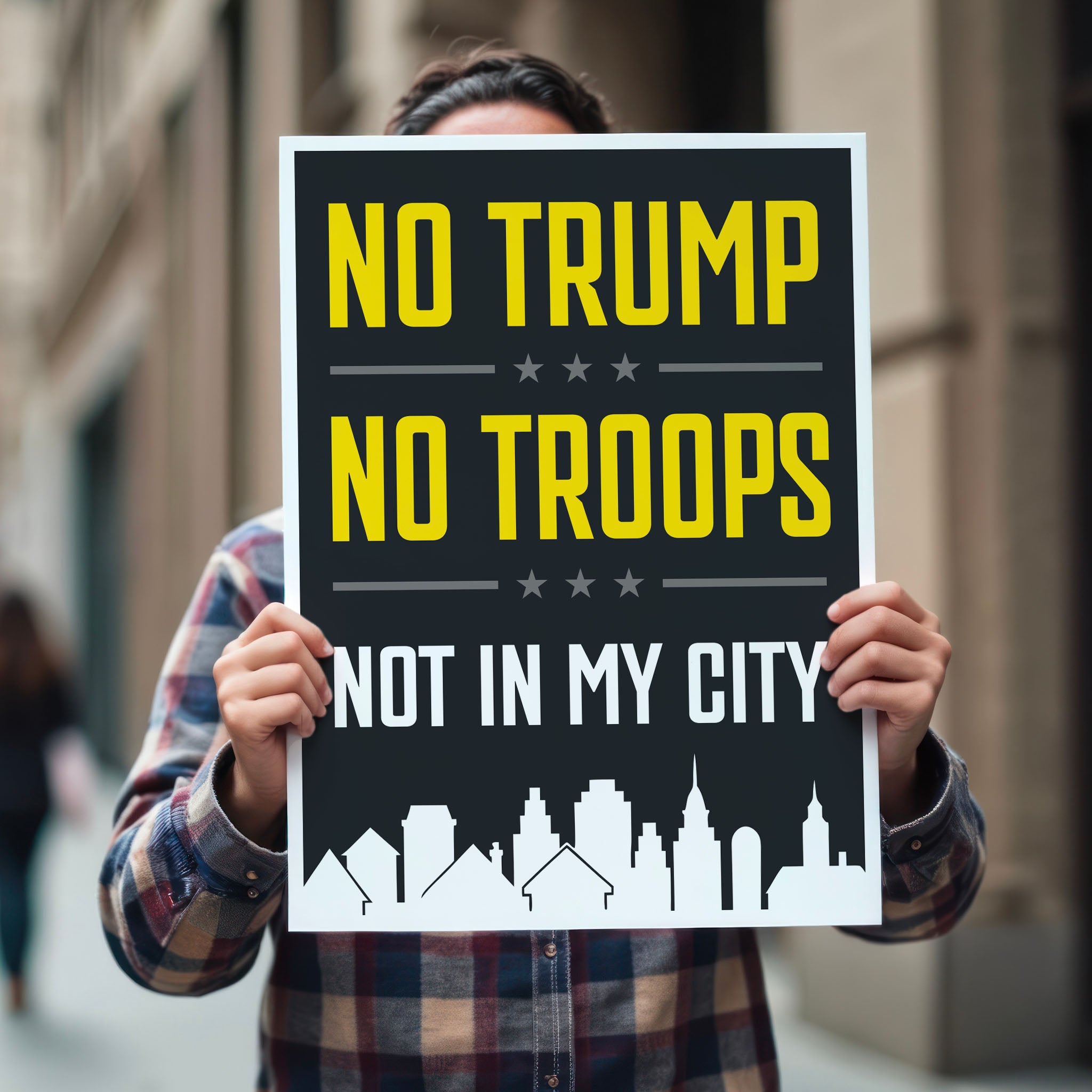 Person holding protest sign with bold yellow and white text reading “No Trump No Troops Not in My City” over a dark background with a city skyline silhouette.