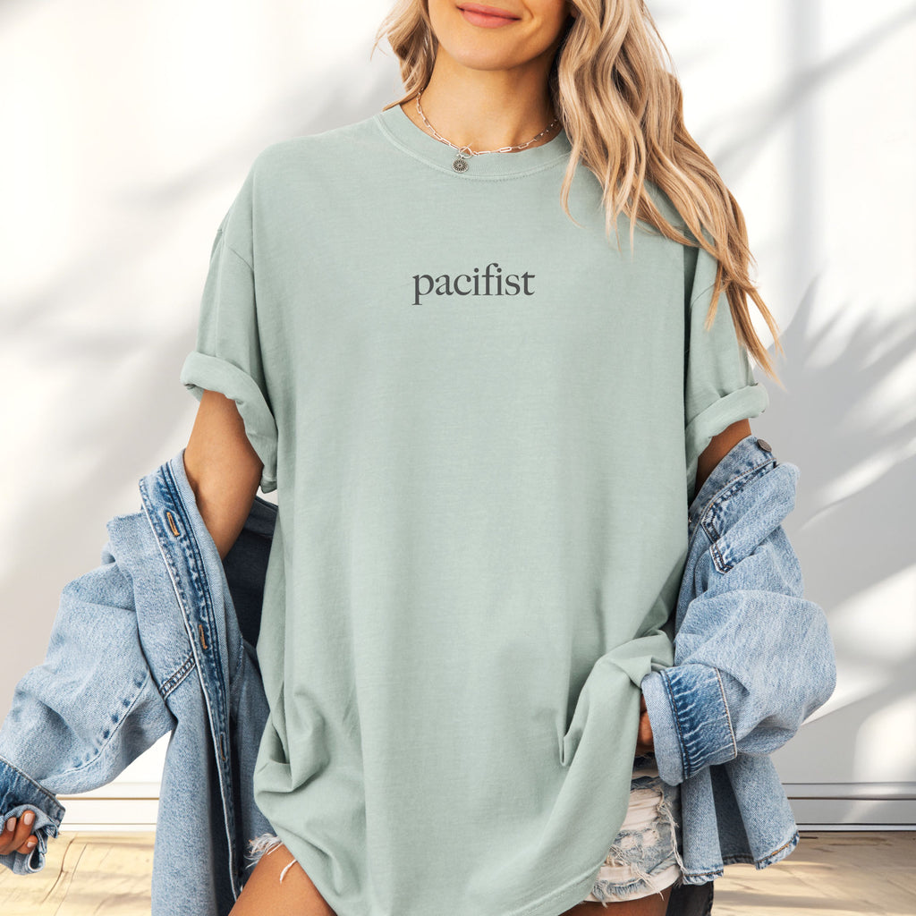 Female model wearing bay t-shirt with minimalist serif text reading "pacifist."