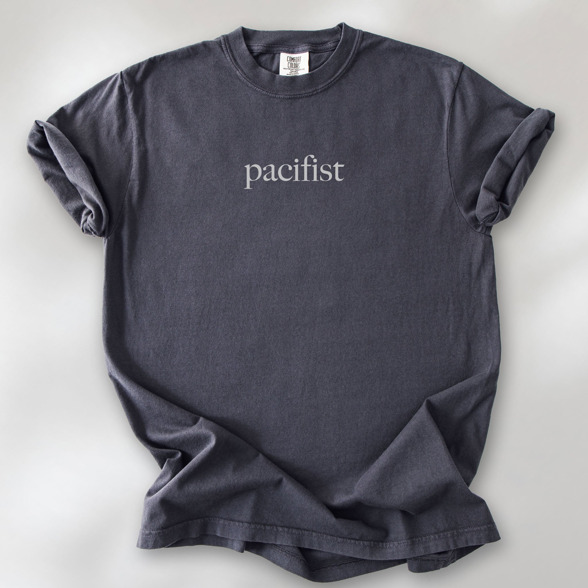 Graphite t-shirt with minimalist serif text reading "pacifist."
