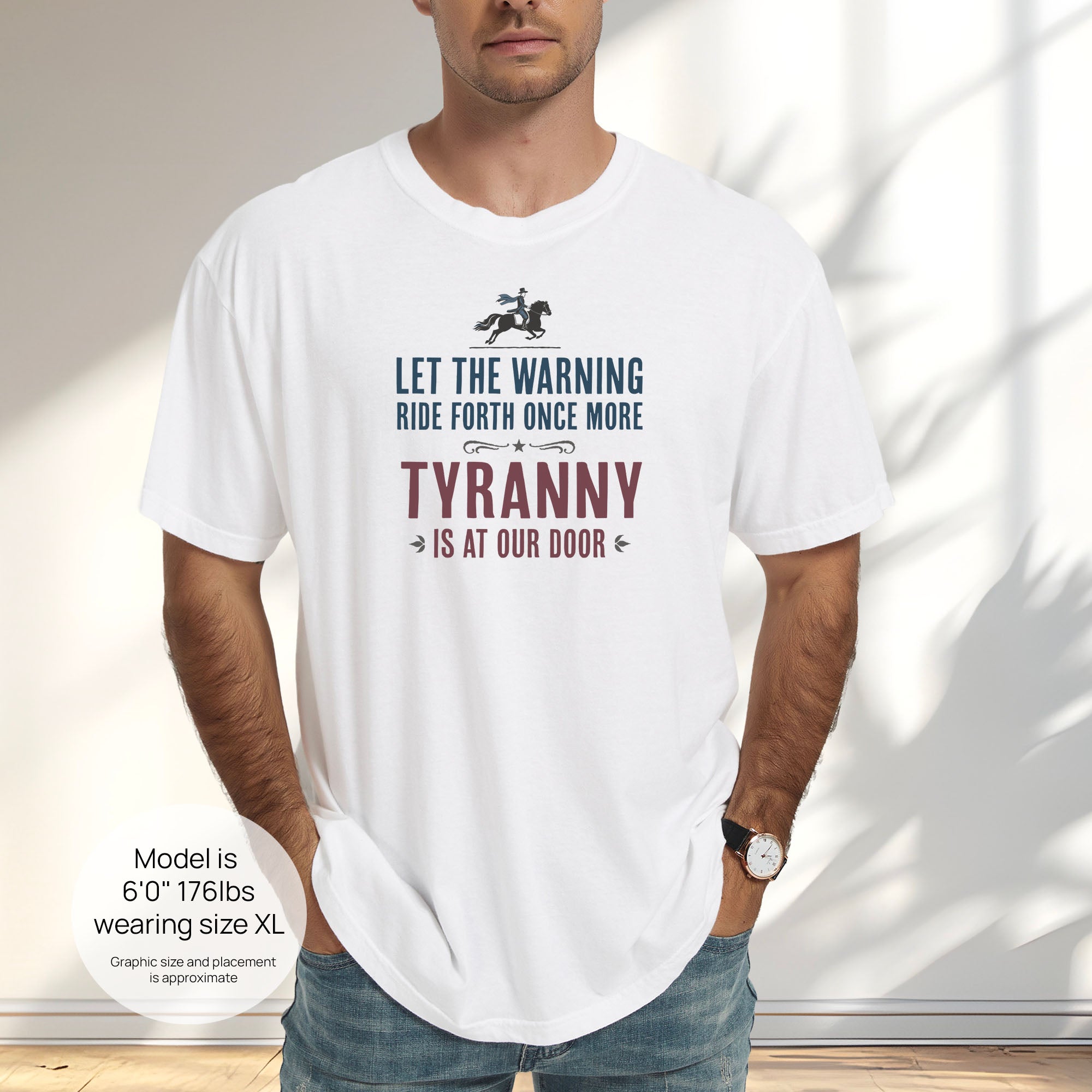 Male model wearing white t-shirt with a silhouette of Paul Revere on horseback and the text “Let the warning ride forth once more – Tyranny is at our door” in blue and red. Includes size and fit information for the model who is 6 feet 0 inches, 176 pounds, and wearing a size XL shirt.
