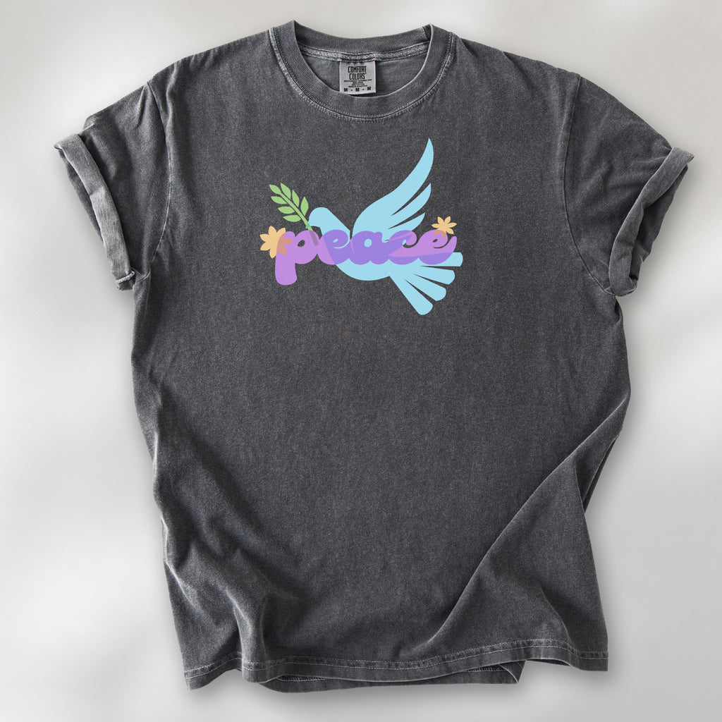 Pepper t-shirt featuring a colorful retro peace dove carrying an olive branch with the word "peace" in groovy 1970s-style lettering. 