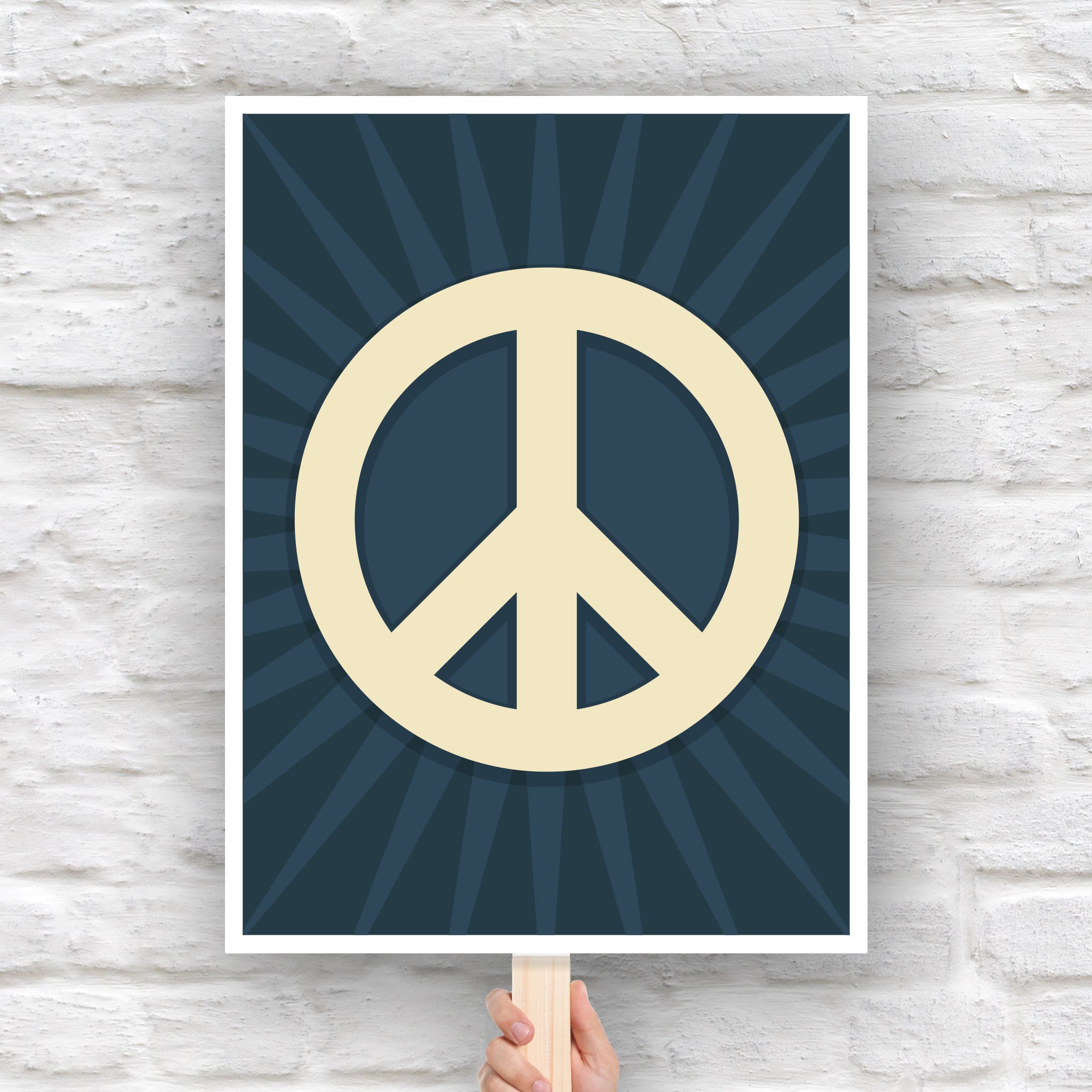 Protest sign with a large pale gold peace symbol in the center on a dark blue background with a burst emanating from the symbol.