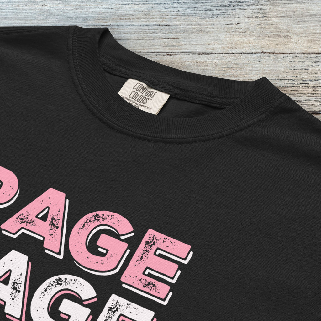 Closeup detail of black protest t-shirt with bold pink and white text reading “rage rage against the dying of your rights” – feminist anti-trump activist shirt.