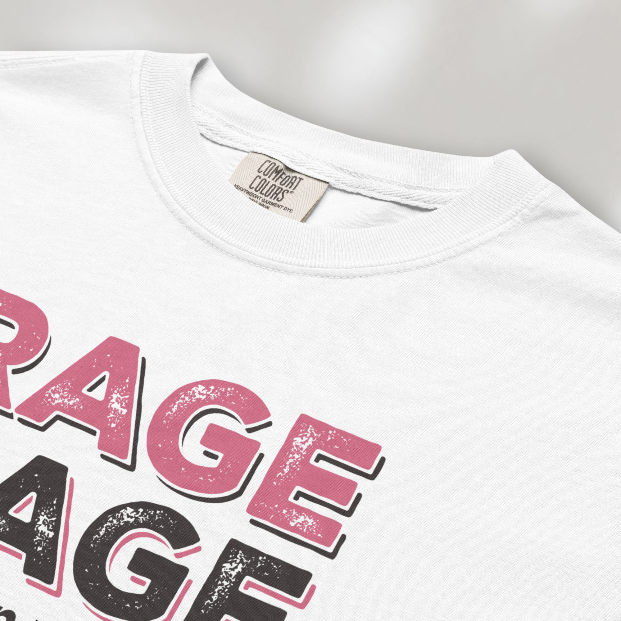 Closeup detail of white t-shirt with distressed bold text that reads "rage rage against the dying of your rights".