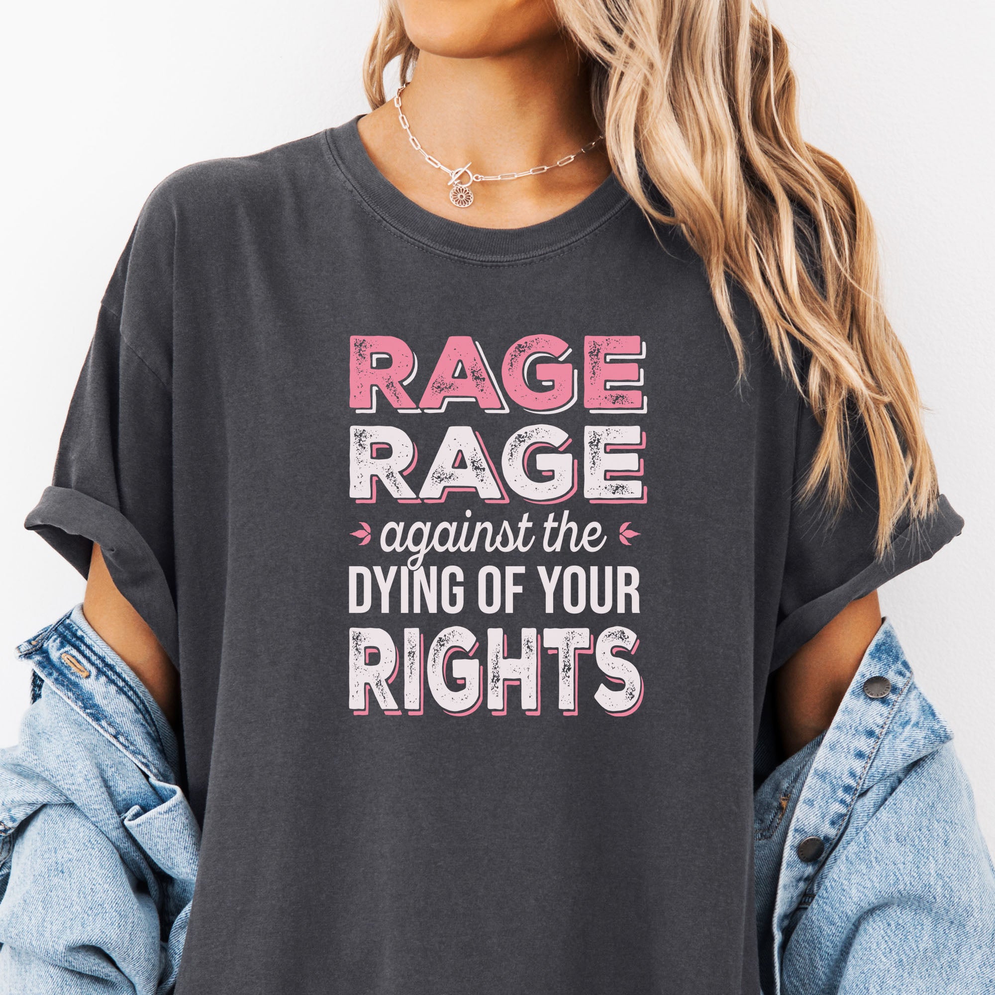 Female model wearing oversized pepper t-shirt with distressed bold text that reads "rage rage against the dying of your rights".