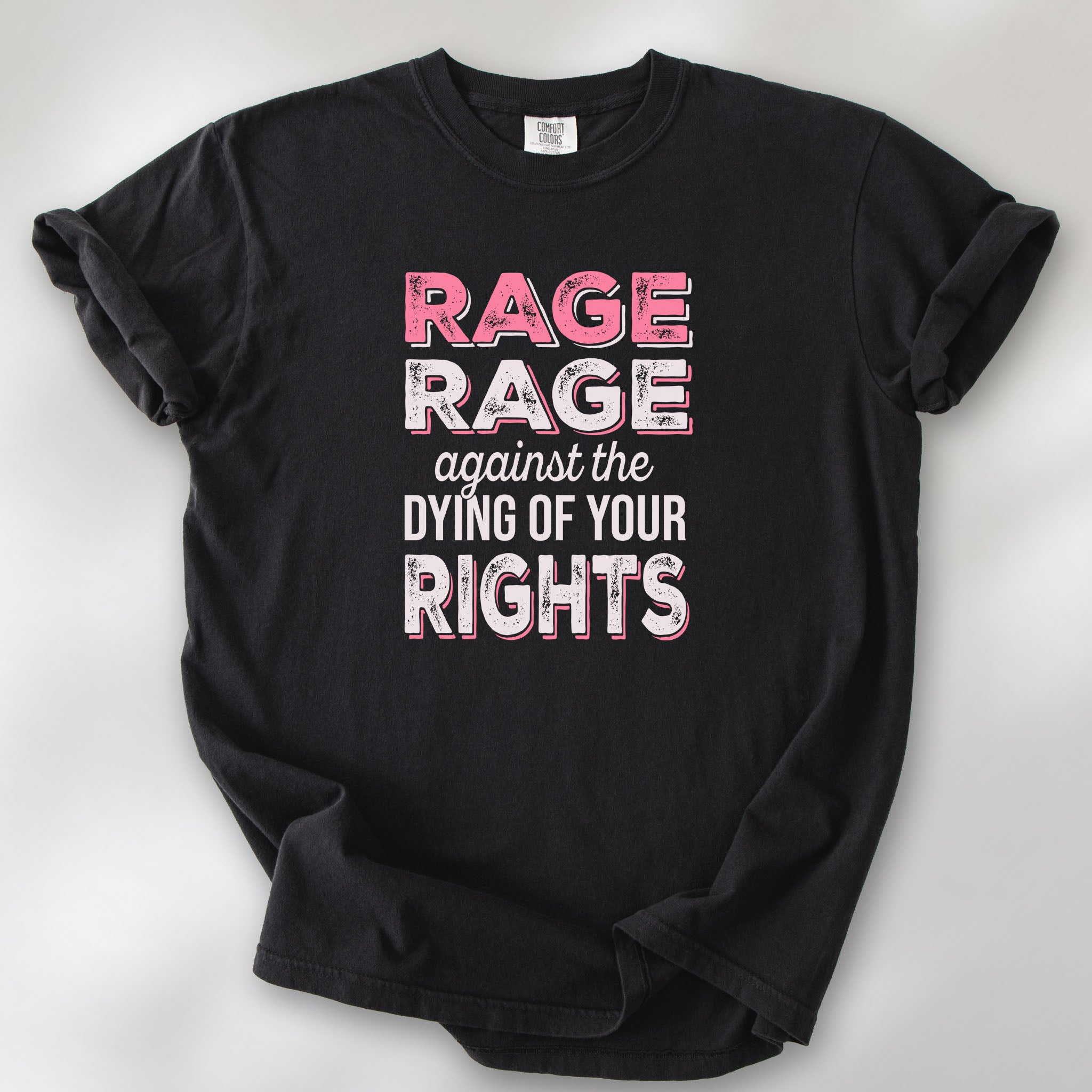 Black protest t-shirt with bold pink and white text reading “rage rage against the dying of your rights” – feminist anti-trump activist shirt.