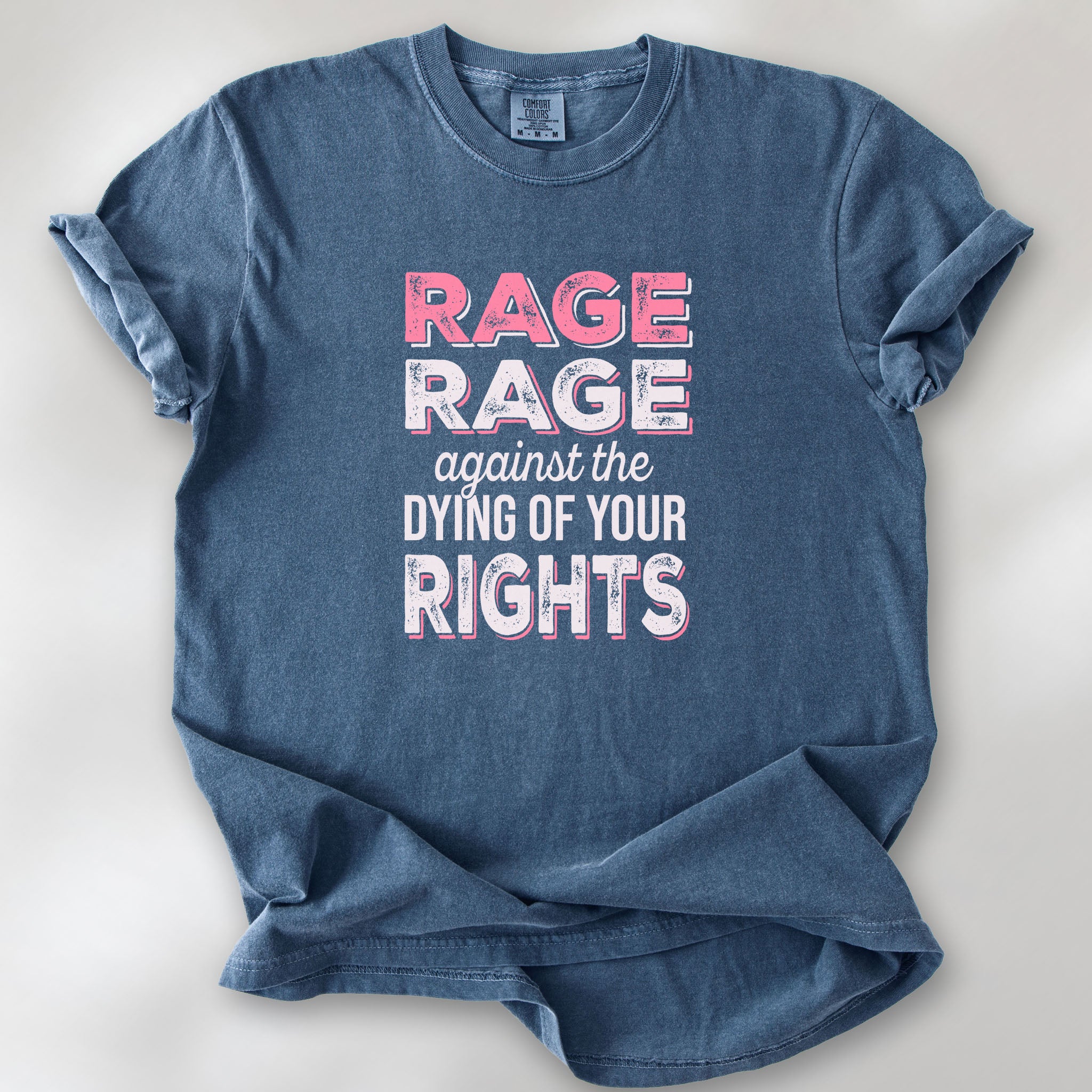 Denim protest t-shirt with bold pink and white text reading “rage rage against the dying of your rights” – feminist anti-trump activist shirt.