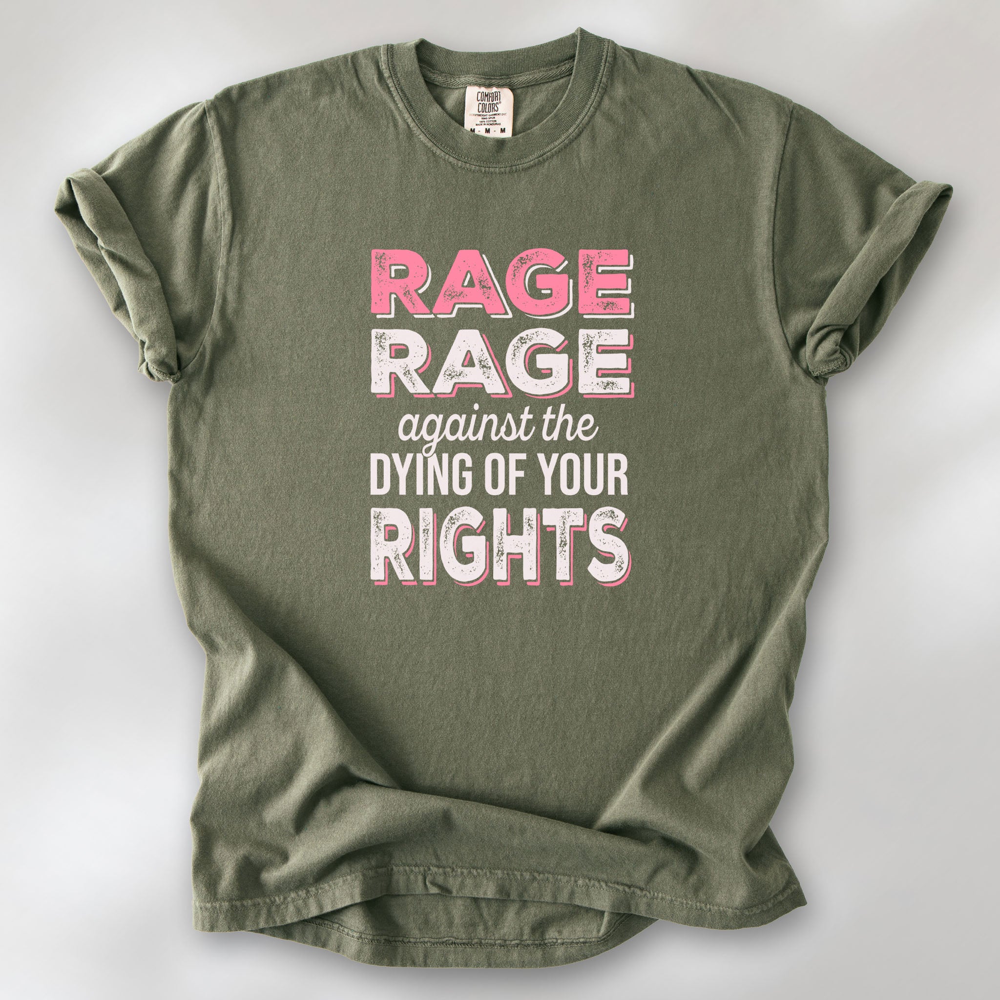Sage protest t-shirt with bold pink and white text reading “rage rage against the dying of your rights” – feminist anti-trump activist shirt.