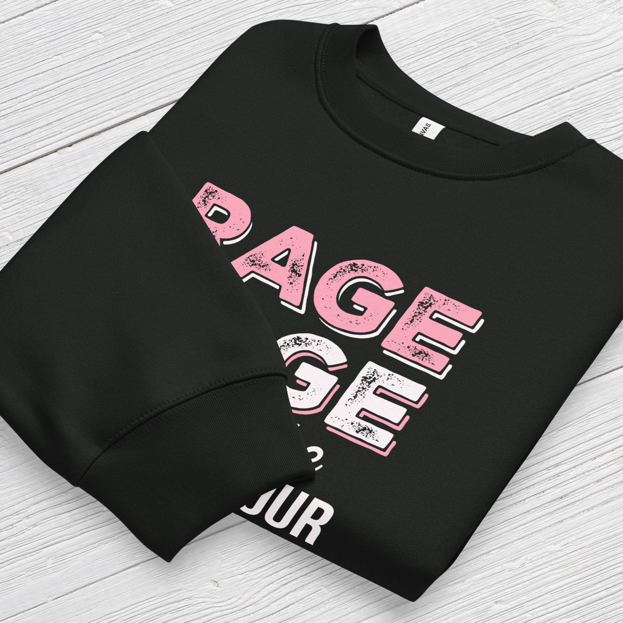Black protest sweatshirt with bold pink and white text reading “rage rage against the dying of your rights” – feminist anti-trump activist shirt. Folded with cuff detail showing.