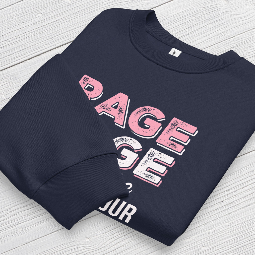 Navy protest sweatshirt with bold pink and white text reading “rage rage against the dying of your rights” – feminist anti-trump activist shirt. Folded with cuff detail showing.