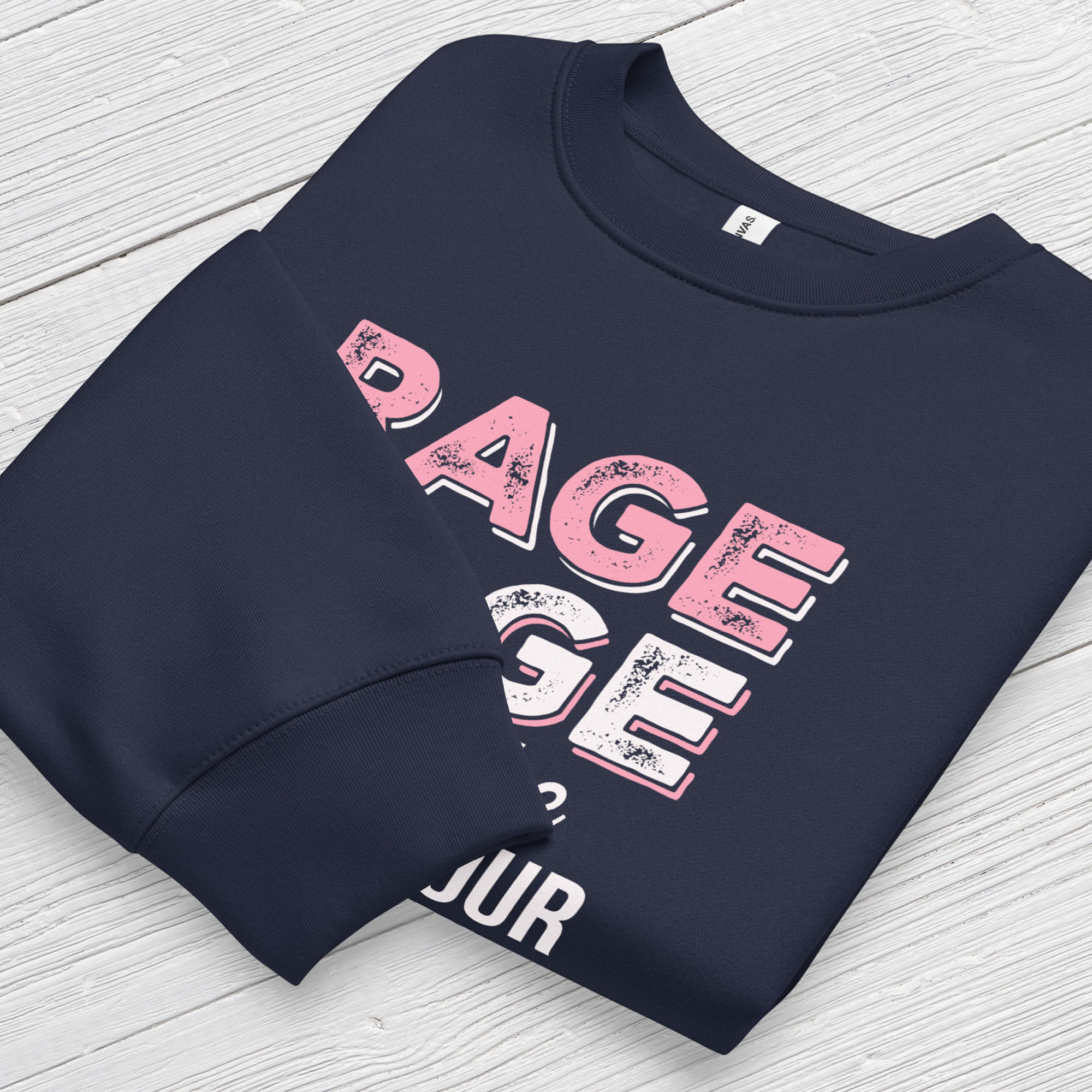 Navy protest sweatshirt with bold pink and white text reading “rage rage against the dying of your rights” – feminist anti-trump activist shirt. Folded with cuff detail showing.