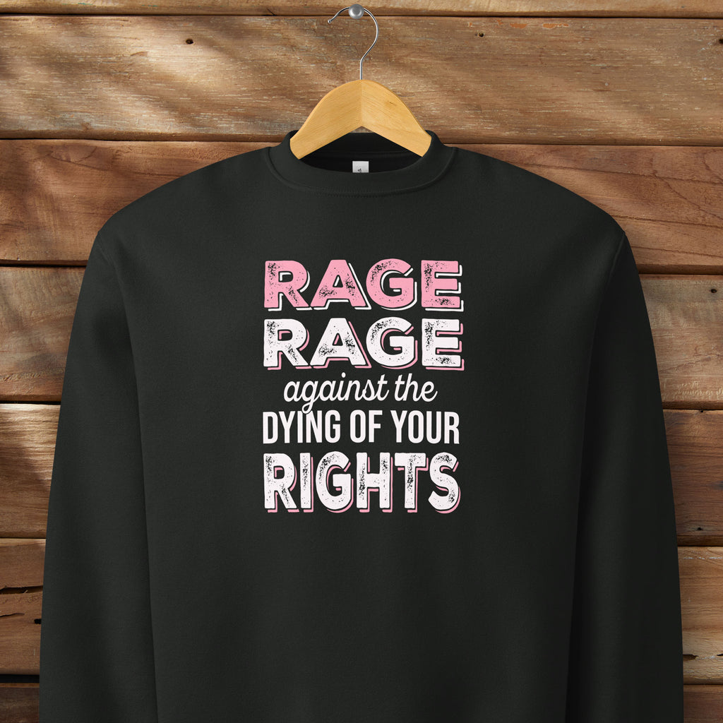 Black protest sweatshirt with bold pink and white text reading “rage rage against the dying of your rights” – feminist anti-trump activist shirt.