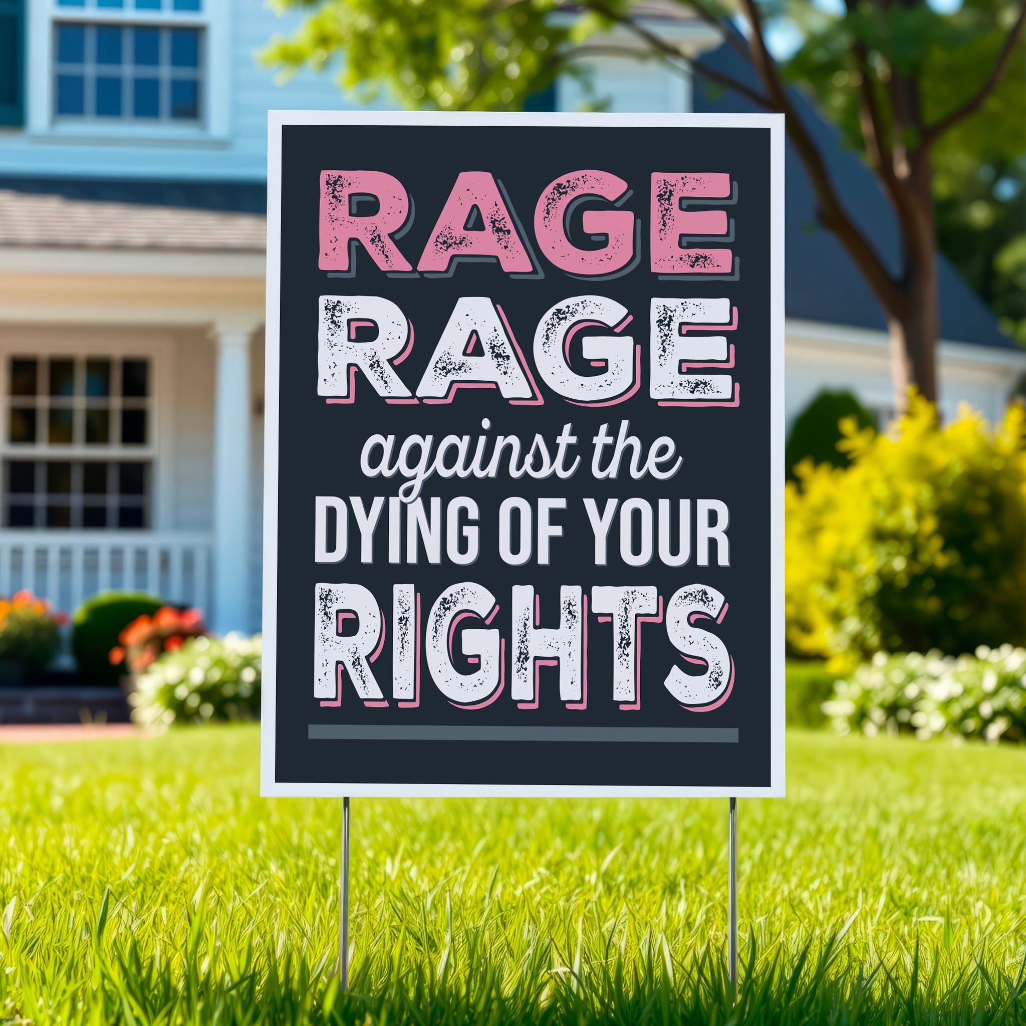 Yard sign with bold distressed text that reads "Rage rage against the dying of your rights," a political twist to the line from a Dylan Thomas poem, planted in a green lawn.