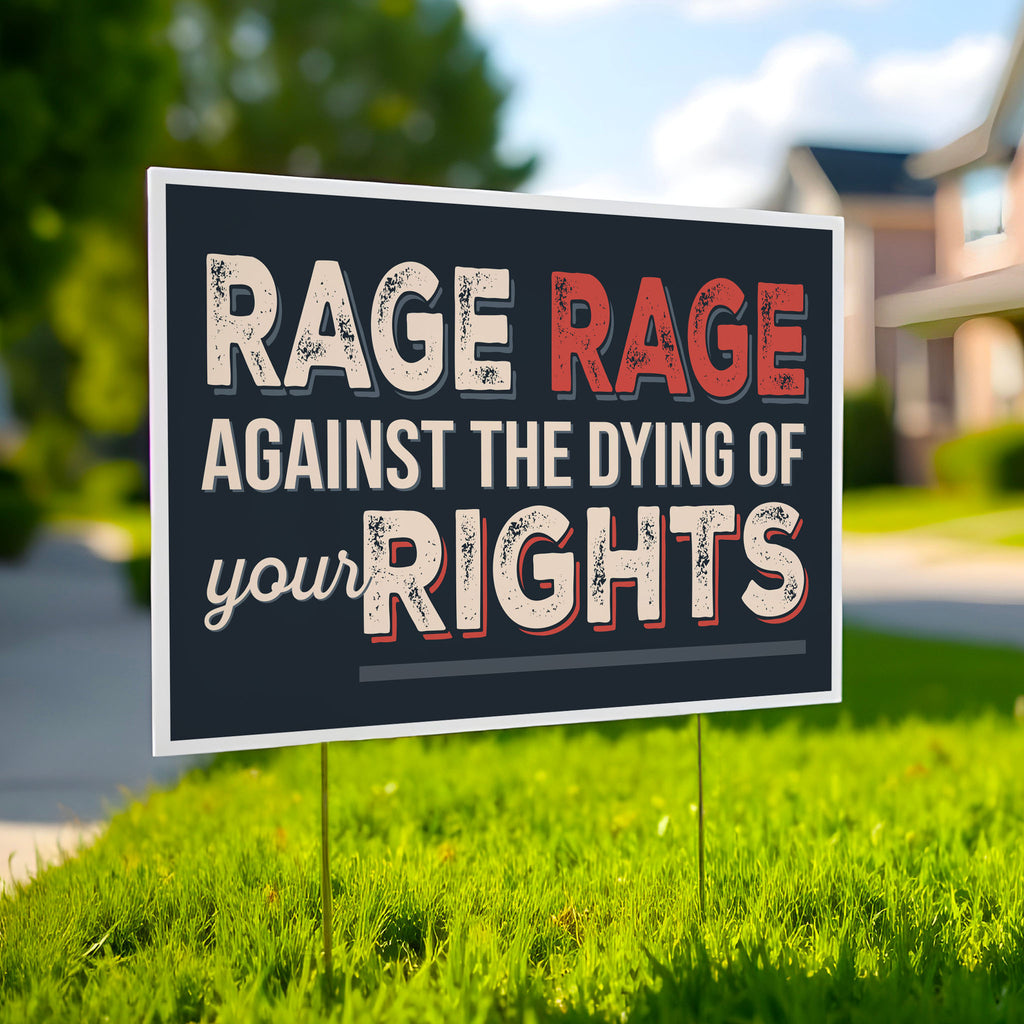 Protest sign with text that reads "Rage rage against the dying of your rights," a political twist to the line from a Dylan Thomas poem, planted in a green lawn.