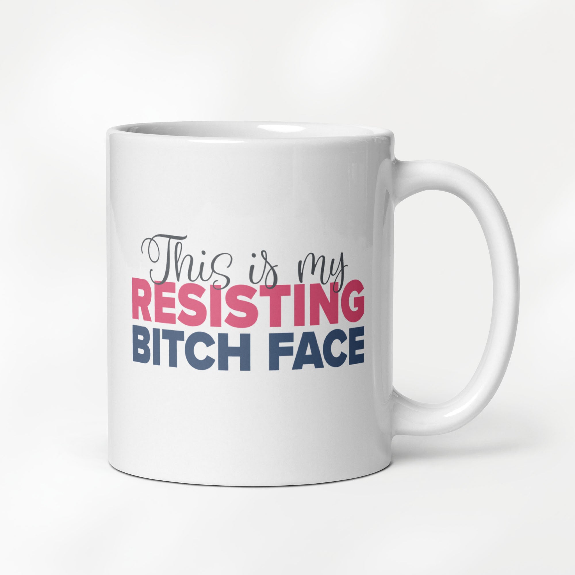 11 ounce white ceramic mug with a graphic that reads "This is my resisting bitch face" in stylized text.