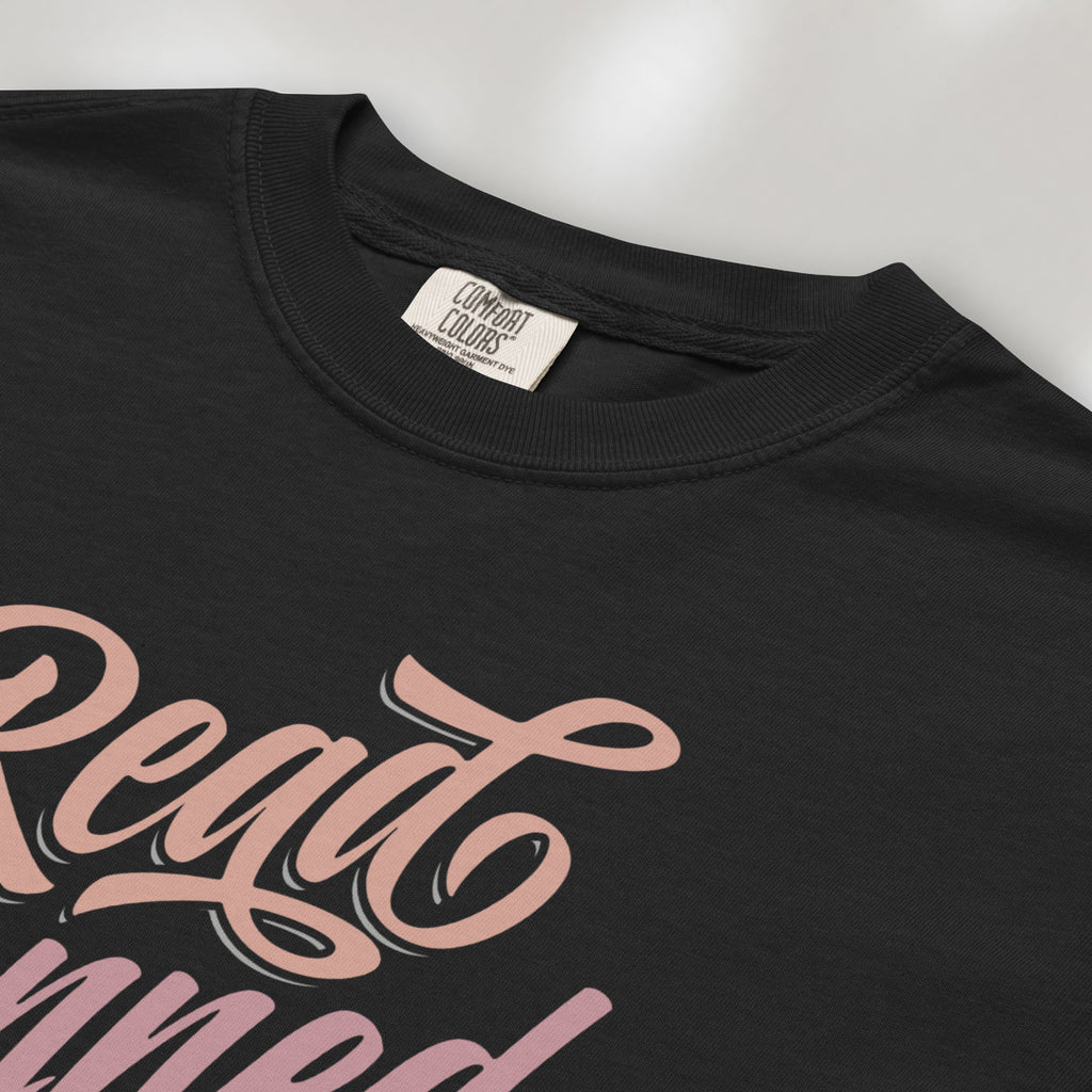 Closeup detail of black black t-shirt with stylized text reading “Read Banned Books” in bold script lettering.
