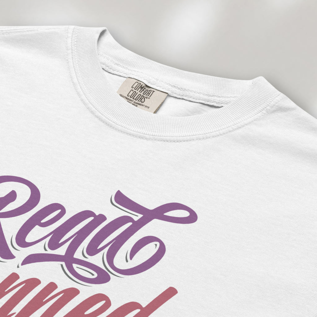 Closeup detail of white t-shirt with stylized text reading “Read Banned Books” in bold script lettering.