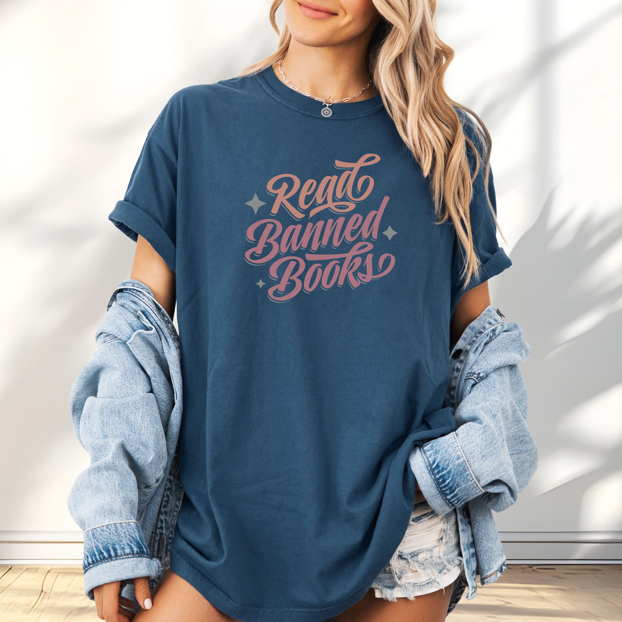Female model wearing oversized midnight t-shirt with stylized text reading “Read Banned Books” in bold script lettering.