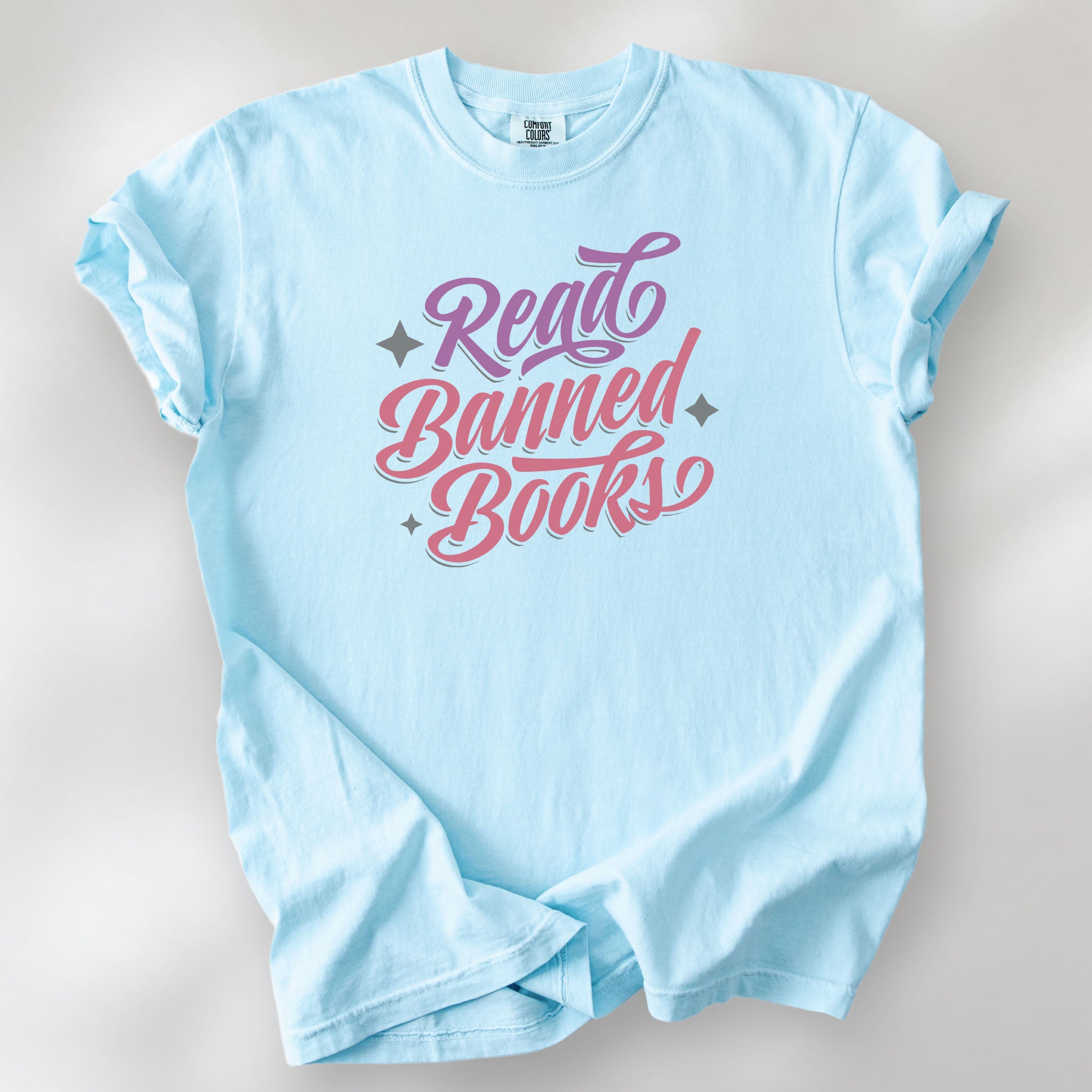 Chambray t-shirt with stylized text reading “Read Banned Books” in bold script lettering.