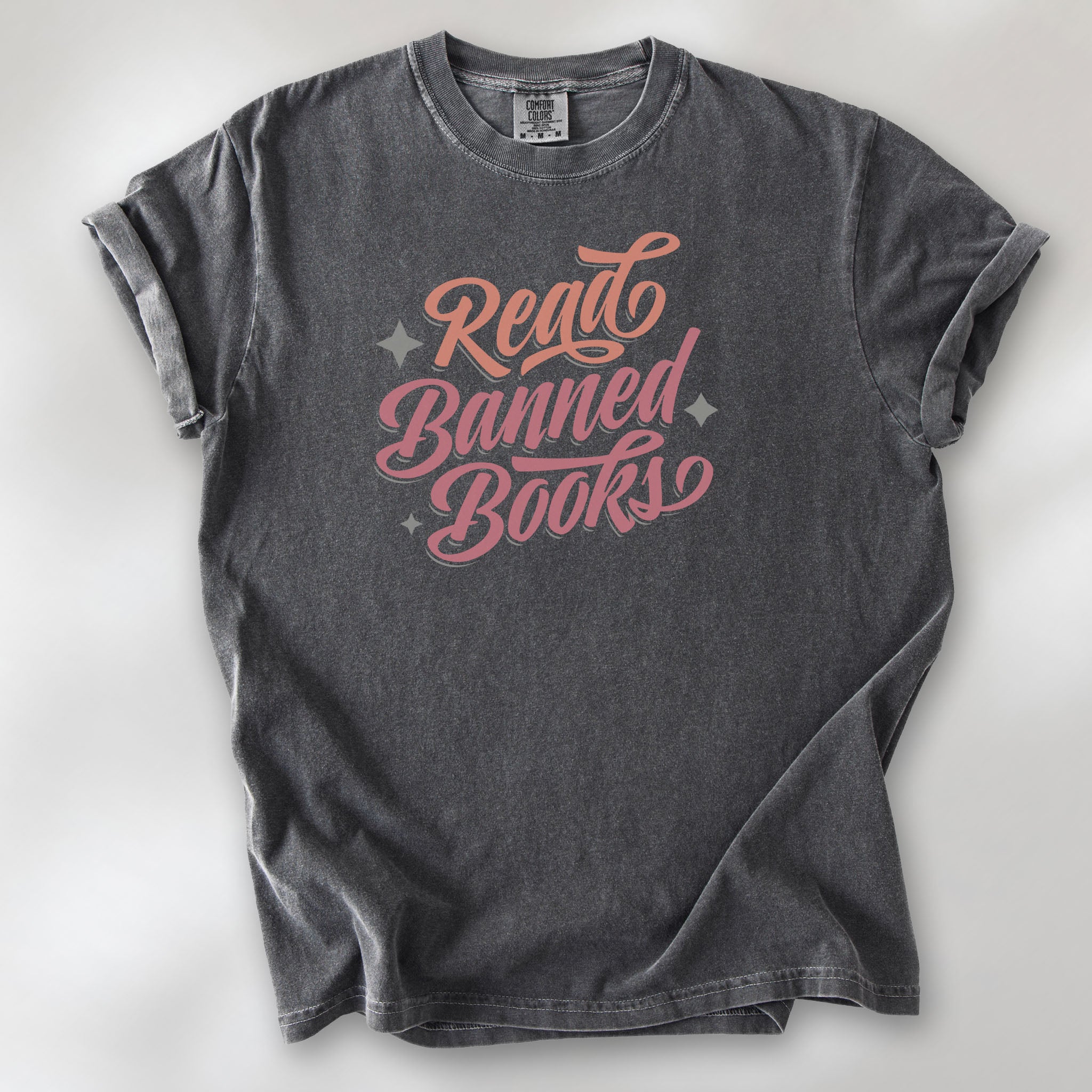 Pepper t-shirt with stylized text reading “Read Banned Books” in bold script lettering.