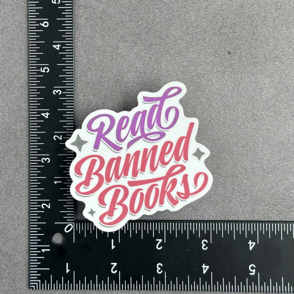 Retro-style "Read Banned Books" die-cut vinyl sticker pictured with ruler showing approximate size of 3 inches by 3 inches.