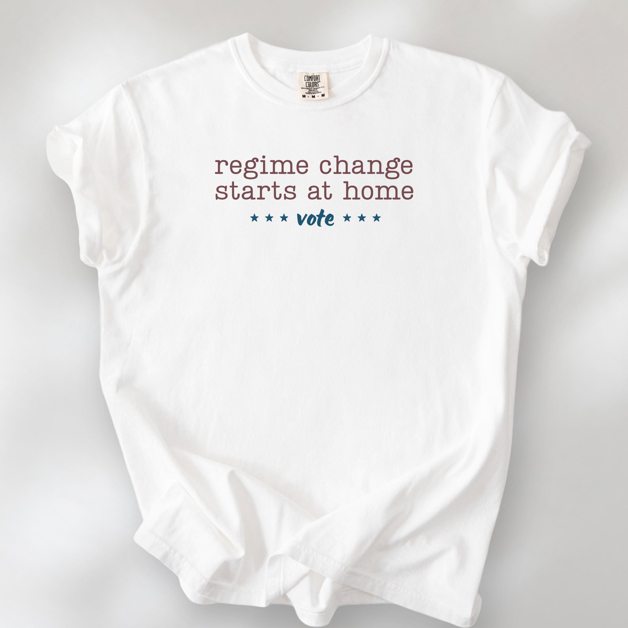 White t-shirt with text that reads "regime change starts at home – vote."