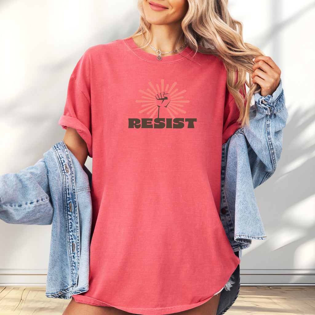 Female model wearing watermelon t-shirt with retro style "resist" text, raised fist, and pinkish burst behind the fist.