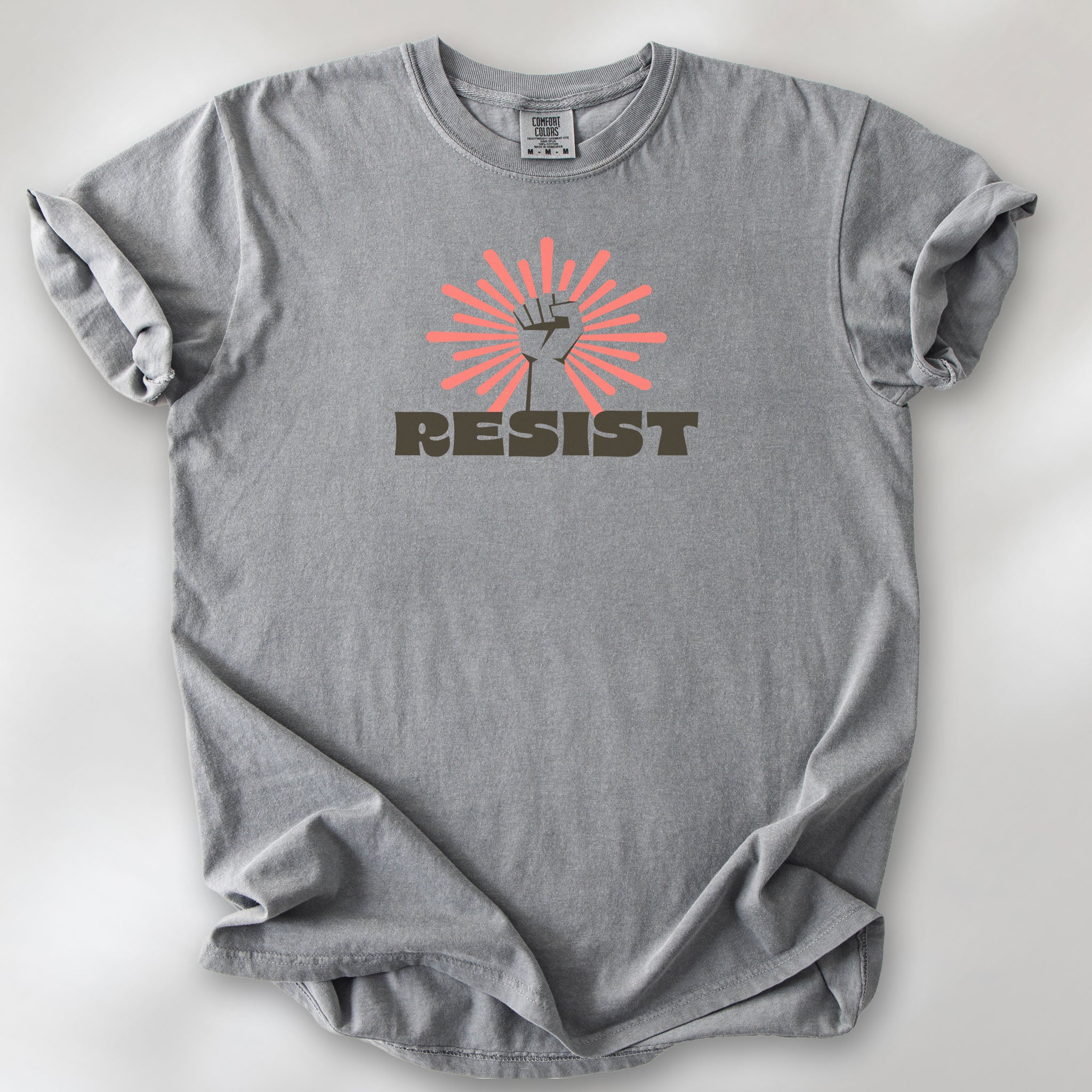 Grey t-shirt with retro style "resist" text, raised fist, and pinkish burst behind the fist.