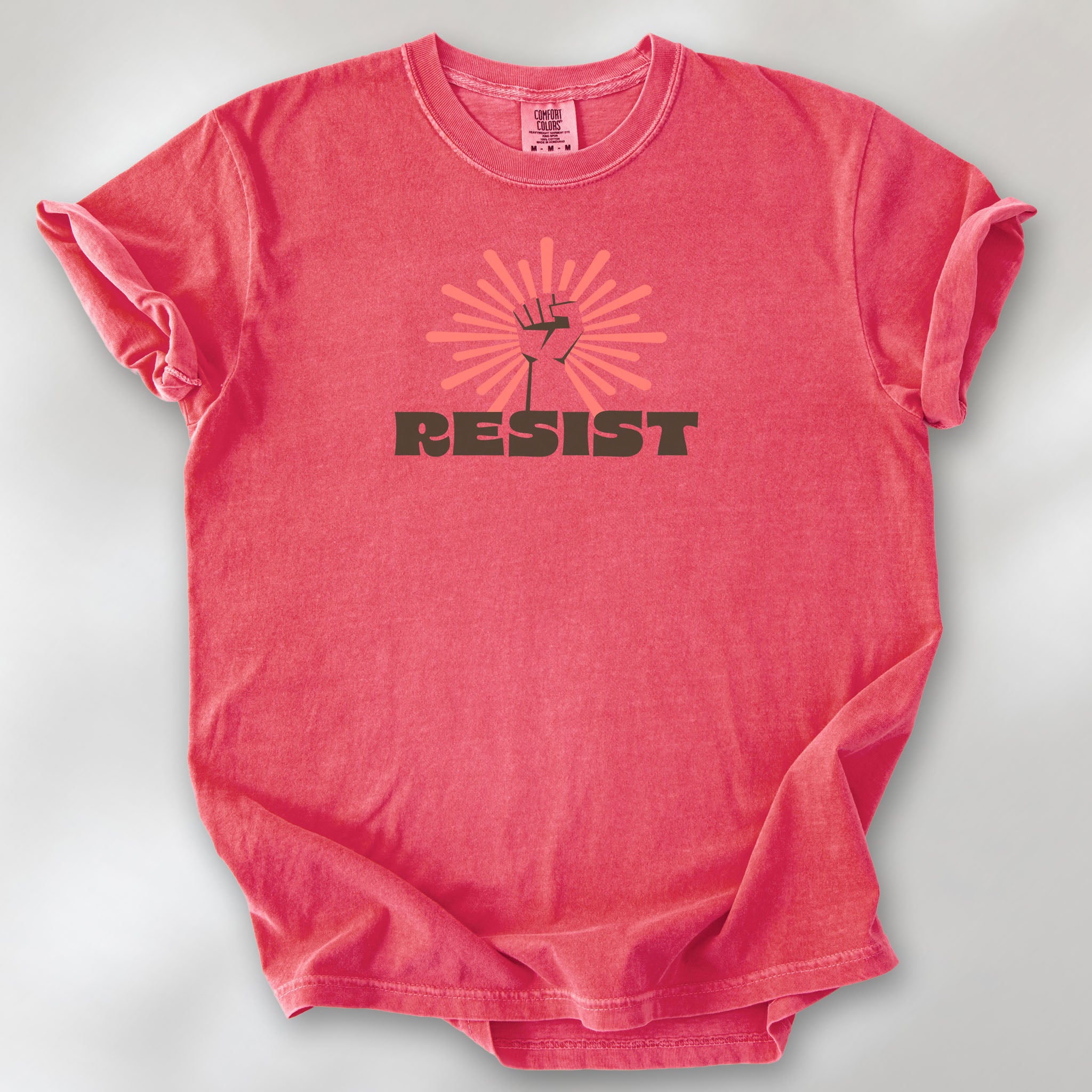 Watermelon t-shirt with retro style "resist" text, raised fist, and pinkish burst behind the fist.