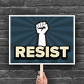 Anti-trump resistance protest sign with a raised fist and the word "Resist" below it.
