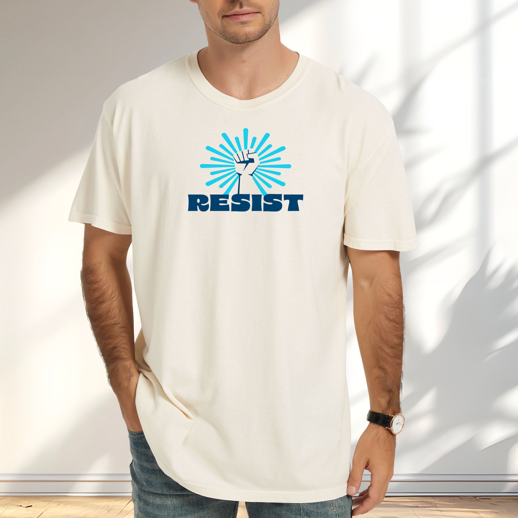 Male model wearing ivory t-shirt with blue Minnesota-themed “Resist” retro text and stylized raised fist design with burst.