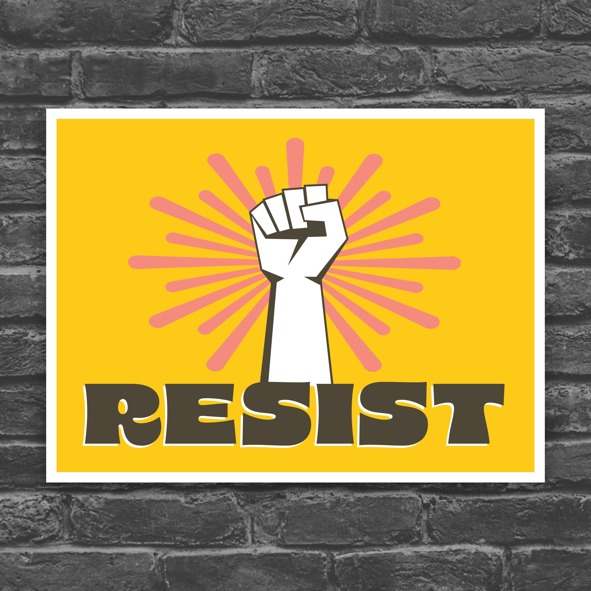 Printable protest sign with a white raised fist and the word “resist” in bold brown letters on a bright yellow background with pink radiating lines.