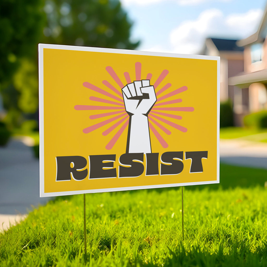 Printable yard sign with a white raised fist and the word “resist” in bold brown letters on a bright yellow background with pink radiating lines, planted in a green lawn.