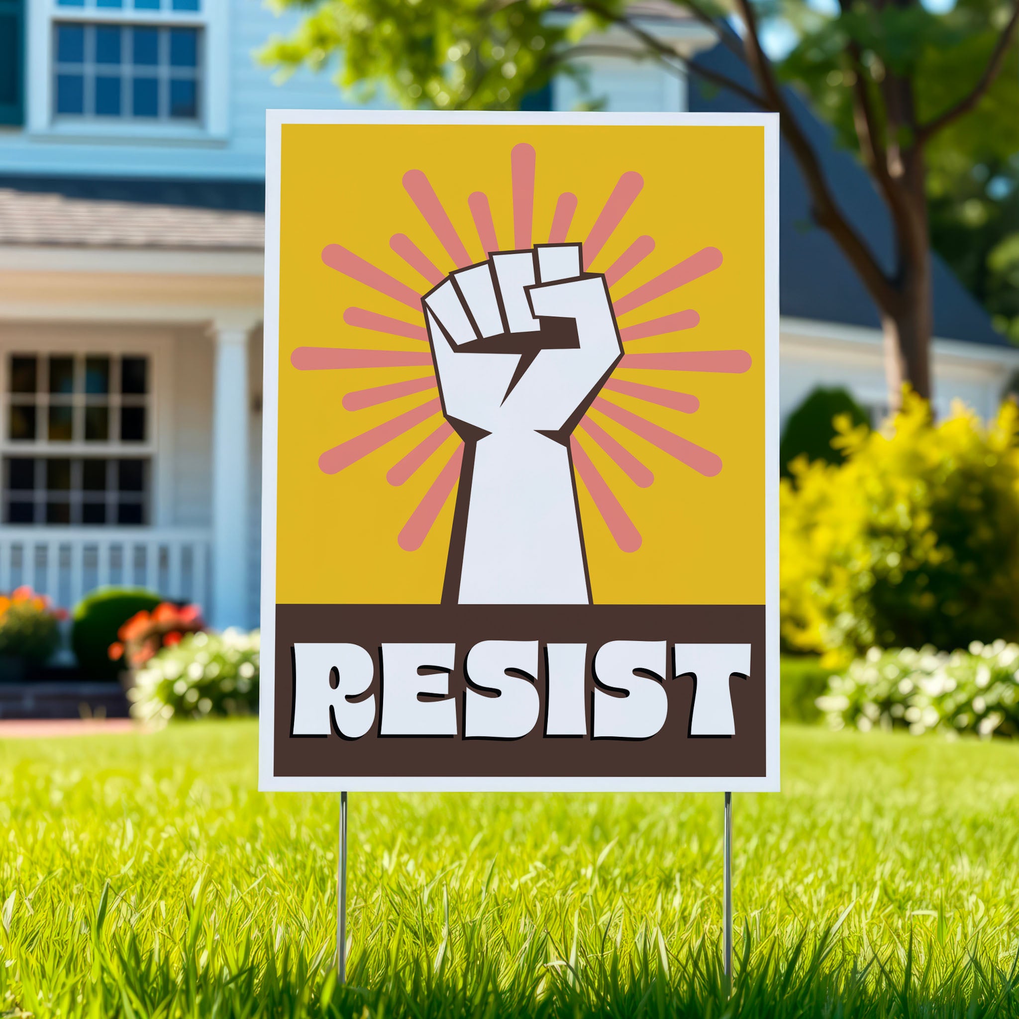 Yard sign with yellow background behind a white raised fist and pink burst, with the retro-styled bold word "resist" below, reversed out of brown, planted in a green lawn.