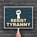 Downloadable, printable anti-Trump protest sign with bold gold text on a blue background hat reads "resist tyranny" below a raised fist.