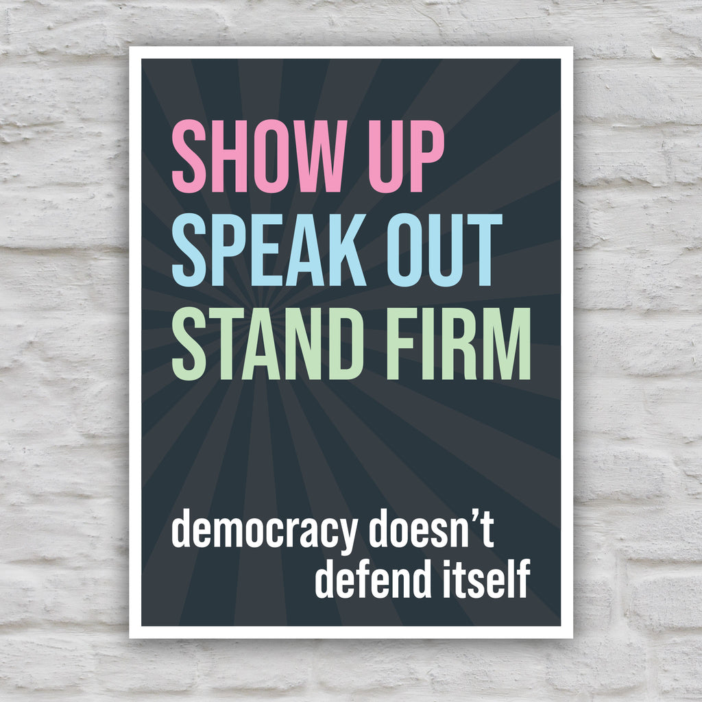 Color version of protest sign with dark background with subtle burst, bold colorful text that reads "show up, speak out, stand firm", then white bold text that reads "democracy doesn't defend itself."