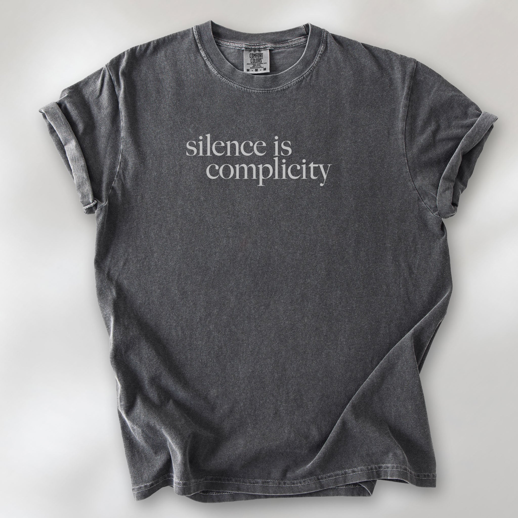 Pepper t-shirt with minimalist serif text reading “silence is complicity."