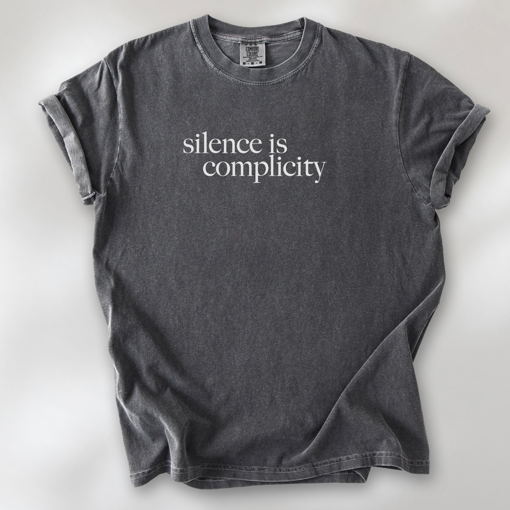Pepper t-shirt with minimalist serif text reading “silence is complicity."