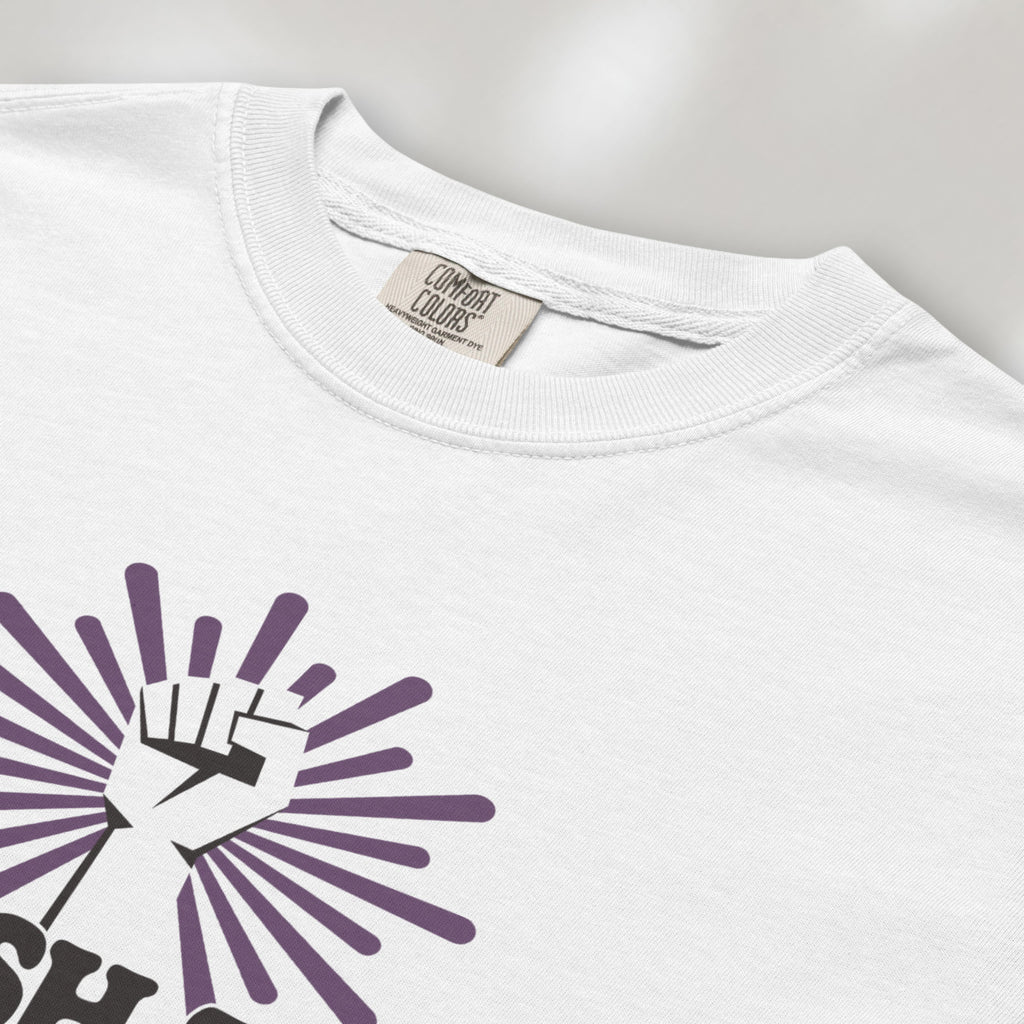 Closeup detail of white t-shirt with a raised fist graphic and purple burst above the text “Smash the Patriarchy.”