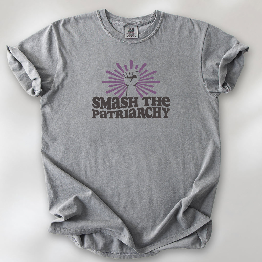 Grey t-shirt with a raised fist graphic and purple burst above the text “Smash the Patriarchy.”